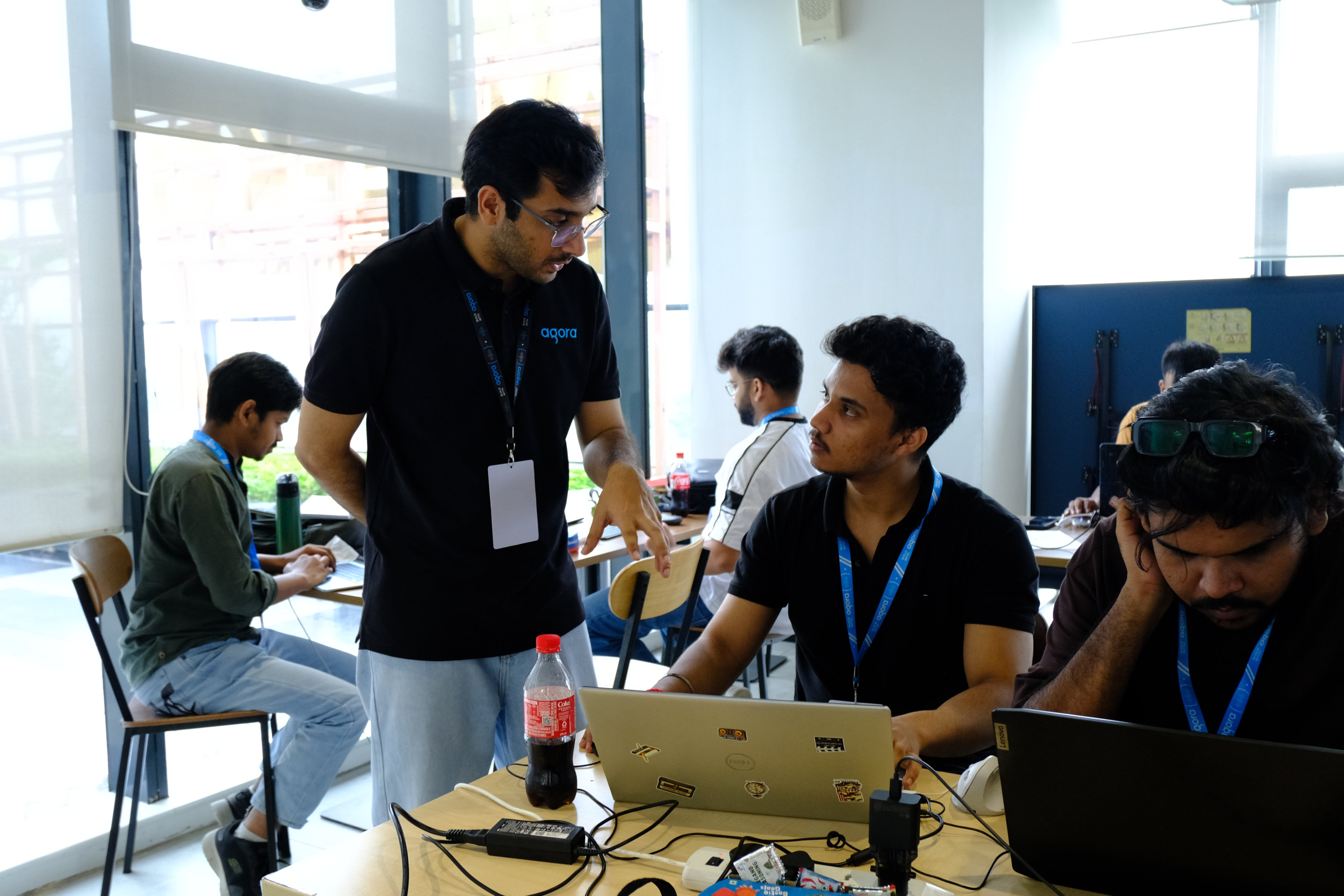 Akshay helping participants working on laptops at a developer event